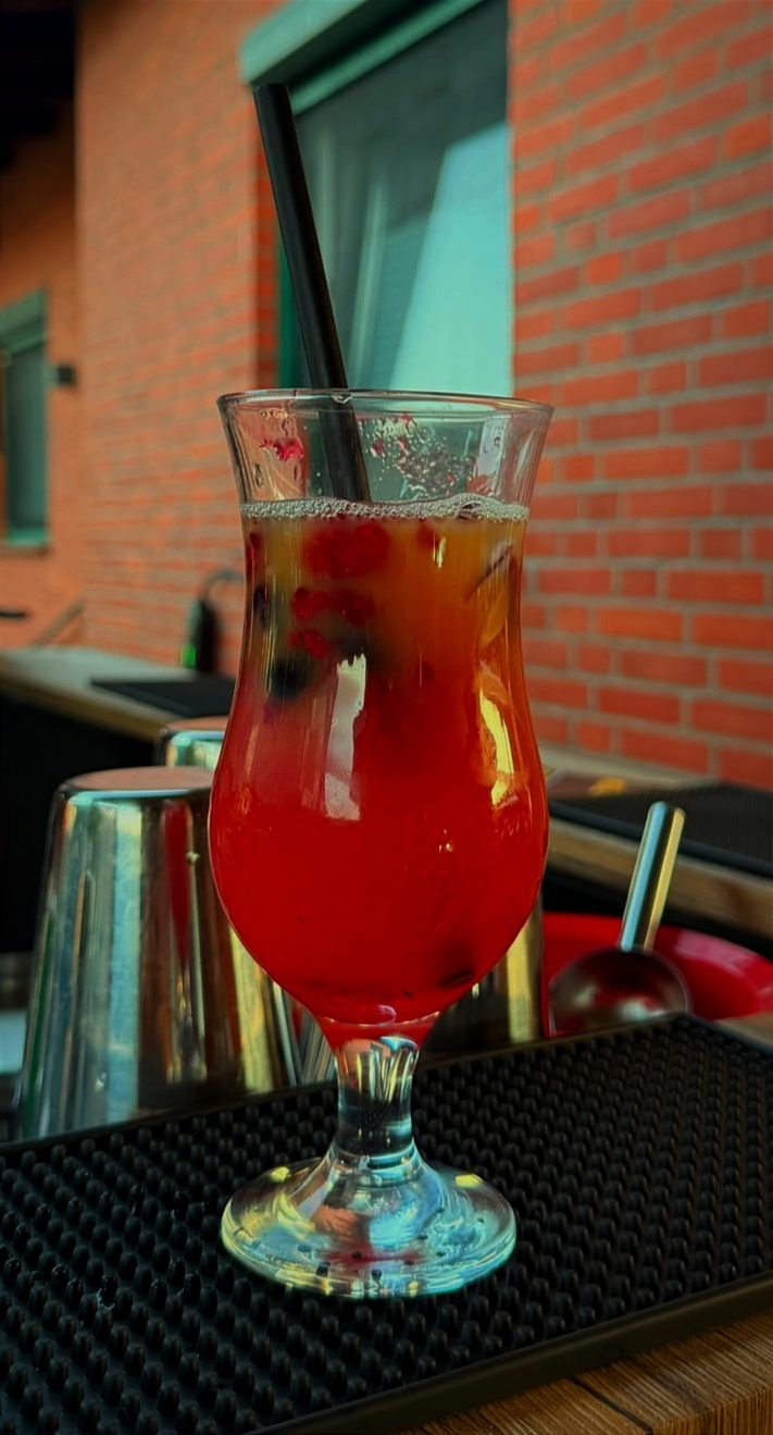 Roter Cocktail mit Beeren garniert